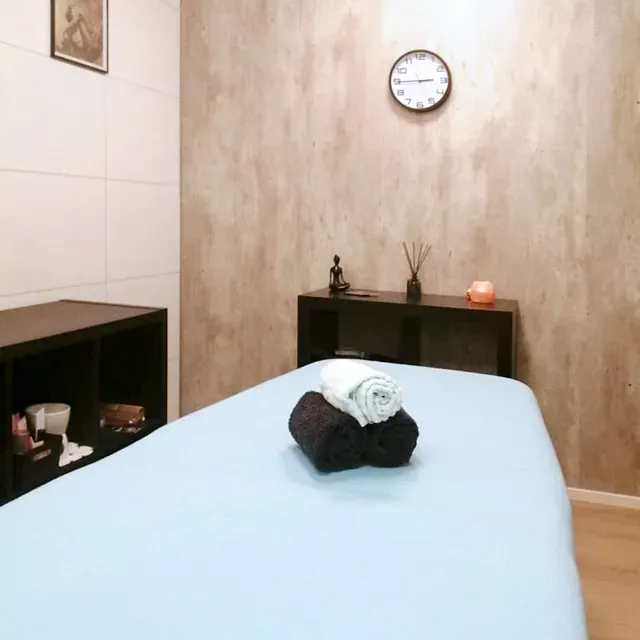 Behandlingsrom med massasjebenk og rolige detaljer.