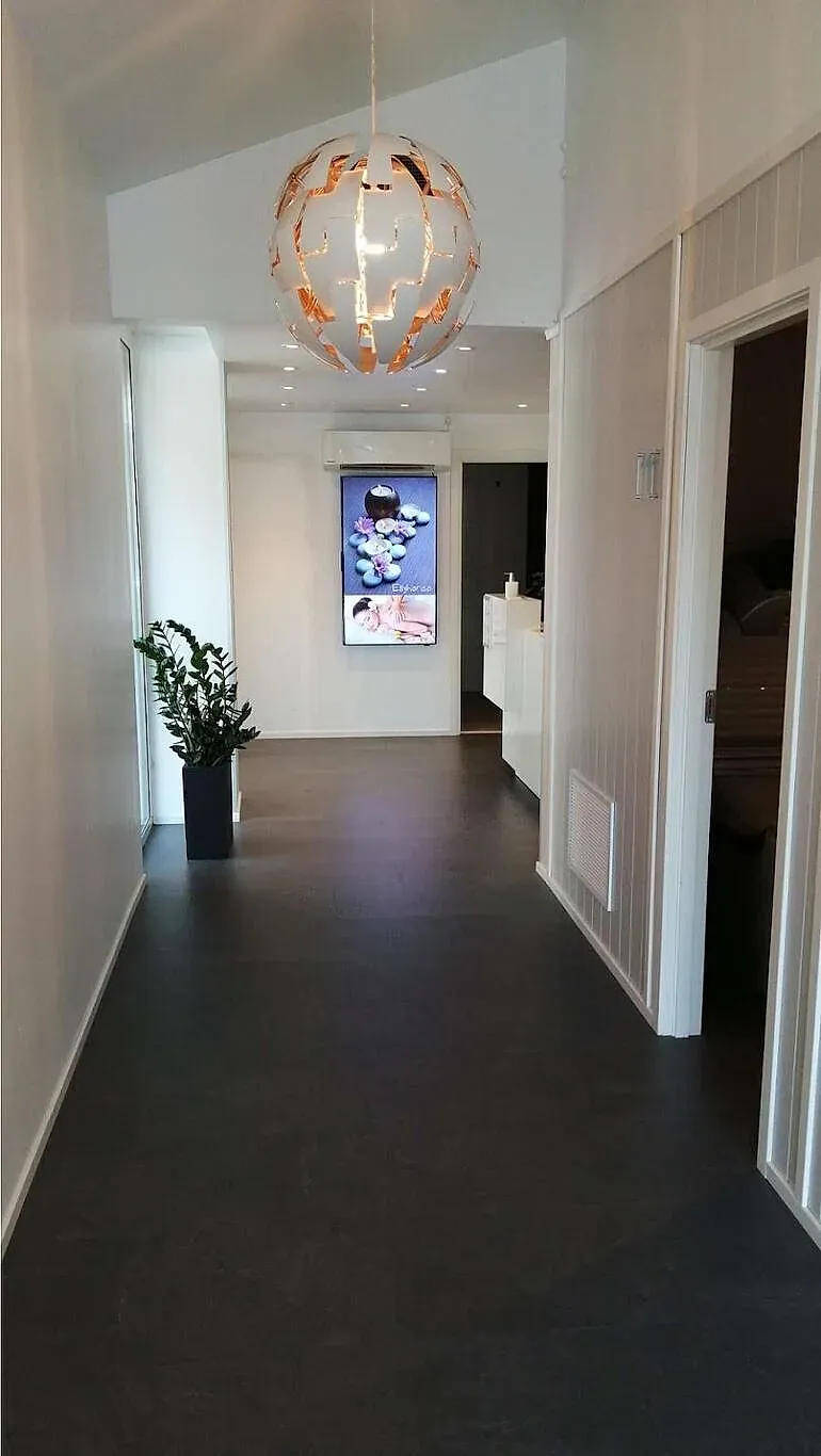 Lang korridor med plantelys og Ellyhansa-skjerm i enden, gir rolig atmosfære.